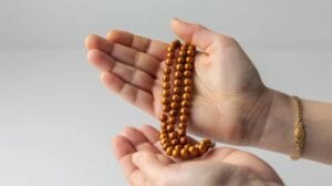 closeup hands holding wooden prayer beads serene reflective gesture